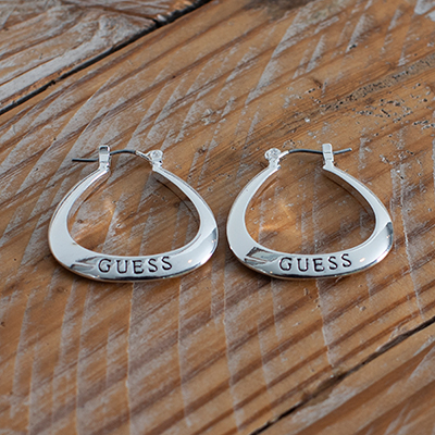 GUESS<sup>&reg;</sup> Logo Hoop Earrings - These silver tone triangle shaped hoops feature rounded edges and "Guess" engraving. Measurement 1" with snapbar closure. 